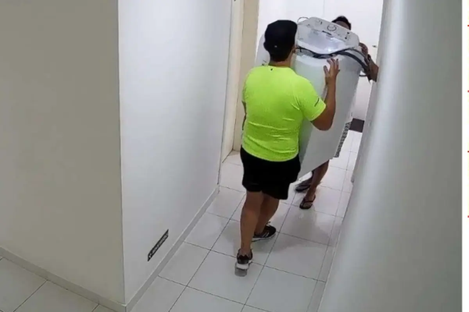 Corretor de imóveis Roger Kogi Tabata retirando máquinas de lavar de um dos apartamentos que administrava (Foto: Cedida ao Mais Goiás)